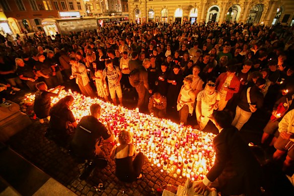 People light candles on the main square in Graz’s city centre after the deadly school shooting.