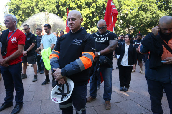 Workers stand for a moment’s silence in honour of paramedic Steven Tougher at Hyde Park in Sydney during a May Day march on Monday.