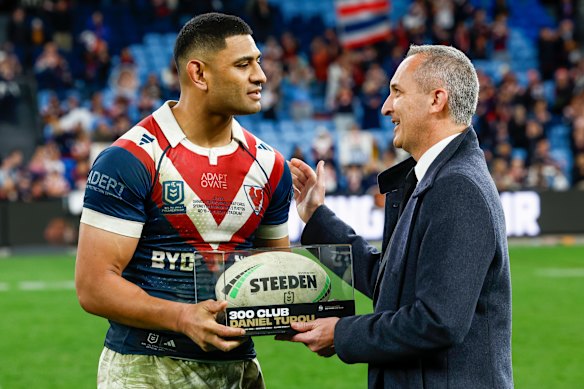 Daniel Tupou receives his 300-game ball from recently departed NRL boss Andrew Abdo.