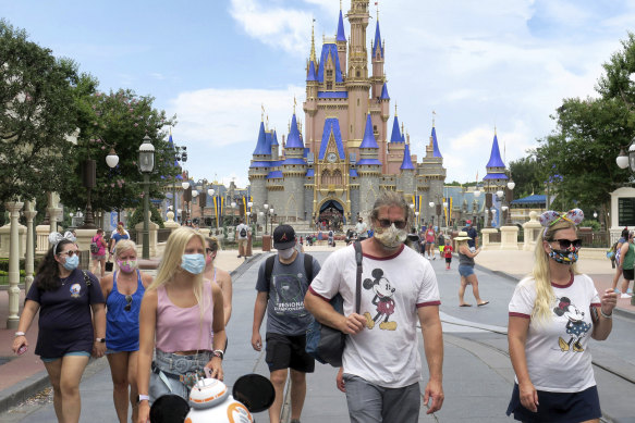 Guests wear masks as required at the Magic Kingdom at Walt Disney World in Florida. 