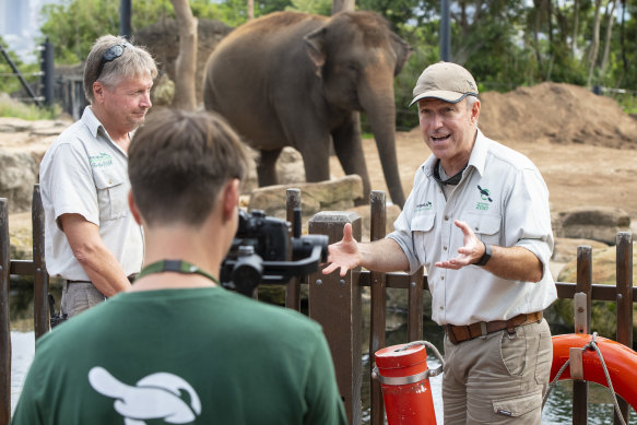 Hayden Turner, Taronga Zoo's manager of guest experiences, right, interviews elephant keeper Darryl Lewry, left, while Guy Dixon films an episode for Taronga TV on Wednesday.