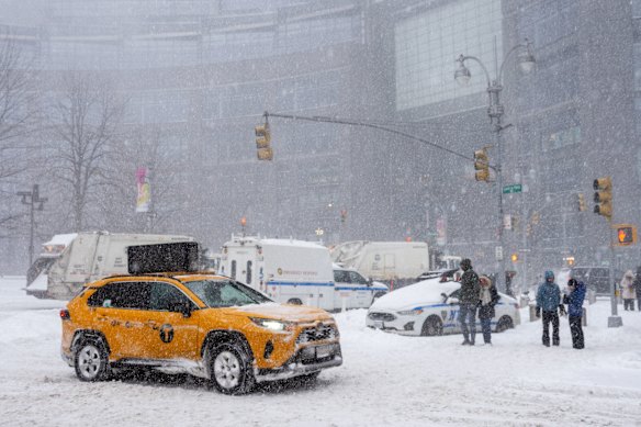 雪に覆われたニューヨークの街を走るタクシー。 