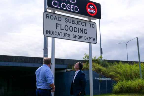Lord Mayor Adrian Schrinner (right) inspects a new automatic flood warning sign.