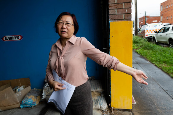 Jenny Lu from Victory Smash and Mechanical Repairs in Marrickville with some of the damaged sand bags she used to protect her property from floods last week.