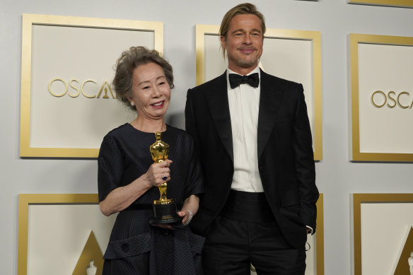 Best actress in a supporting role winner Yuh-Jung Youn poses in the press room with Brad Pitt.