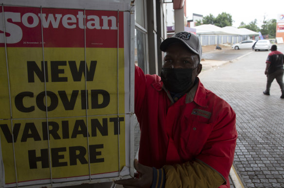 A petrol attendant stands next to a newspaper headline in Pretoria, South Africa in November. 