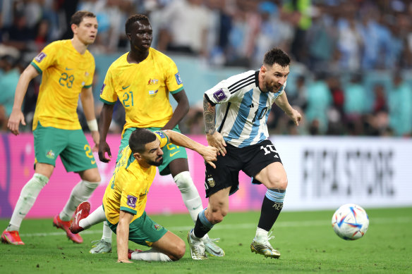 Lionel Messi battles for possession with Aziz Behich.