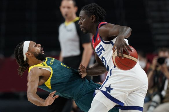 Patty Mills is bundled over by Jrue Holiday.