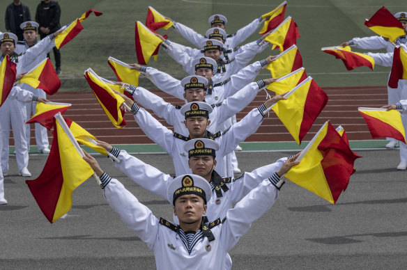 Chinese sailors perform signals to mark the PLA Navy’s 75th anniversary  in Qingdao, China, last week. One of the people charges allegedly passed on sensitive information about German marine propulsion systems – useful for a navy.