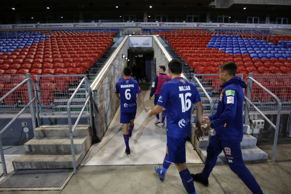 Newcastle Jets players leave an empty McDonald Jones Stadium after the last - and probably final - game of the A-League season.