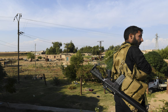 Kurdish soldier Hogar Felak stands watch between Tal Tamr and Ras al-Ain the day after Turkey and Russia struck an agreement.