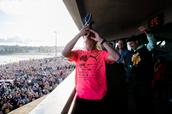 Nedd Brockmann celebrates in front of a large crowd of fans at Bondi Beach after his run from Perth.