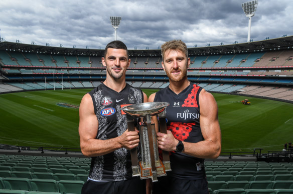 Collingwood captain Scott Pendlebury and Essendon skipper Dyson Heppell at the MCG on Monday with the Anzac Day trophy.