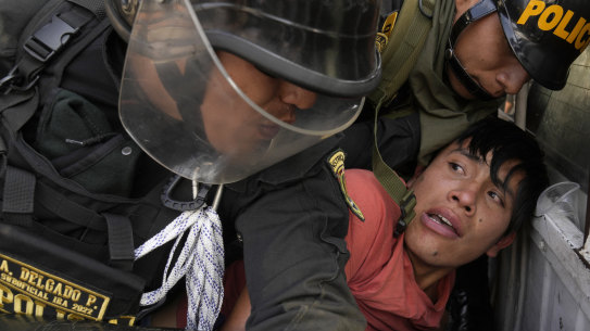 An anti-government protesters who traveled to the capital from across the country to march against Peruvian President Dina Boluarte, is detained and thrown on the back of police vehicle during clashes in Lima.
