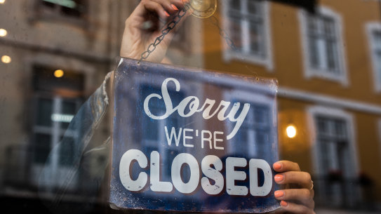 Woman holding We Are Closed sign.
