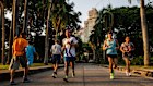 People jog in Lumphini Park at sunrise in order to avoid the midday heat in Bangkok, Thailand.
