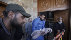 A morgue worker with the body of a Palestinian child killed in an Israeli bombardment of the Gaza Strip at the weekend.