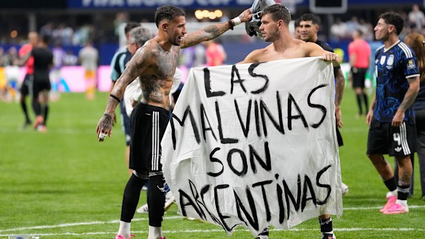 Giovani Lo Celso and Nicolas Otamendi hold the banner.