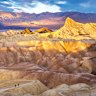 Hikers on the slopes of Zabriskie Point at sunrise.