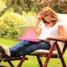 Beautiful mature woman sitting in the garden and working at home. Working from home generic