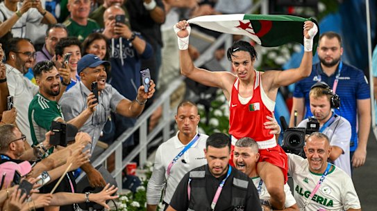 Imane Khelif is carried out of the ring by her coaching staff after winning the gold medal fight.