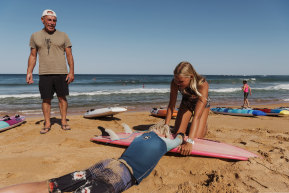 Nick Carroll watches as Newport's Nina Lindley, 15, demonstrates a technique on Dylan Wilkinson so surfers can easily flip someone on to a board in an emergency.