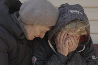 A neighbour comforts Natalya, whose husband and nephew were killed by Russian forces, as she cries in her garden in Bucha.