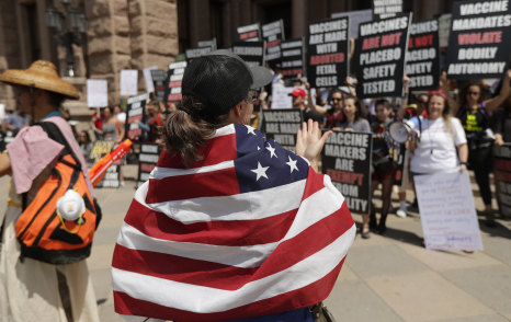 Ignoring social distancing and mandates to wear masks for other face coverings, protesters attend an "Open Texas" rally at the Texas State Capitol on Saturday.