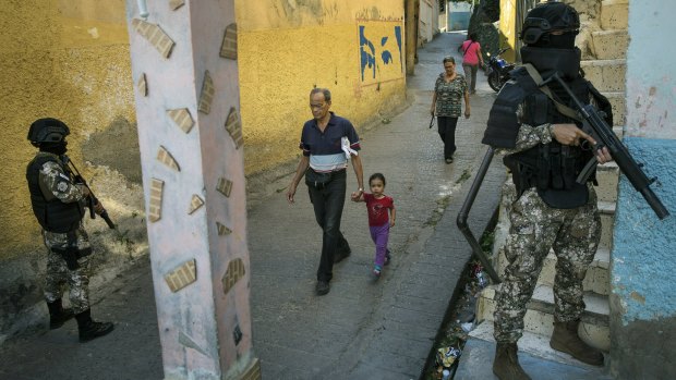 Masked members the National Special Action Forces (FAES), an elite commando unit created for anti-gang operations, patrol a slum in Caracas.