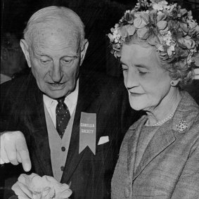 Professor E.G. Waterhouse showing Dame Pattie Menzies the finer points of a camellia bloom  in 1964.