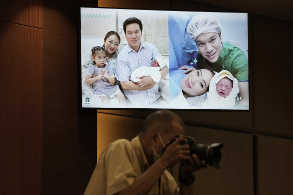 A photographer at a press conference where Paetongtarn Shinawatra and husband Pidok Sooksawas appeared with their children.