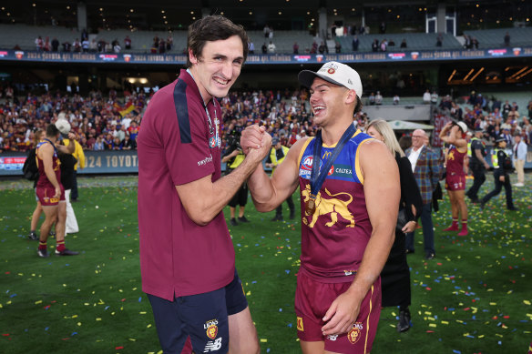 Injured ruckman Oscar McInerney celebrates with teammate Cam Rayner after the premiership win.