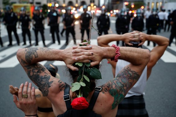 Protesters kneel in front of New York City Police Department officers.