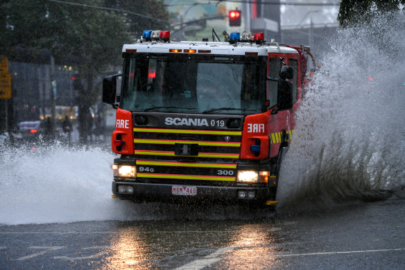 A fire truck travels through deep water caused by Melbourne’s rain on Friday.