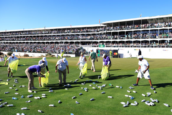 Groundskeepers clean up after the stand at the 16th erupted at Sam Ryder’s hole-in-one.