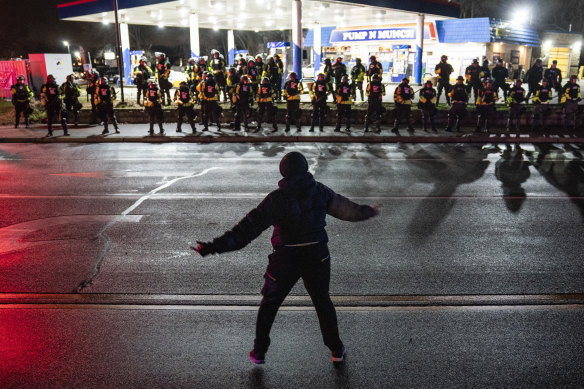 A demonstrator faces off with police during a protest against the fatal shooting of Daunte Wright.