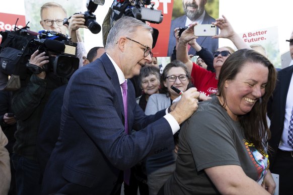 Opposition Leader Anthony Albanese signs a t-shirt during a visit to a pre poll site in the seat of Bass, in Launceston, Tasmania.
