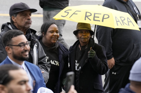Pia Harris, with the San Francisco Housing Development Corporation, second from left, and her mother, Adrian Williams, listen to speakers at a reparations rally outside of City Hall in San Francisco on Tuesday.