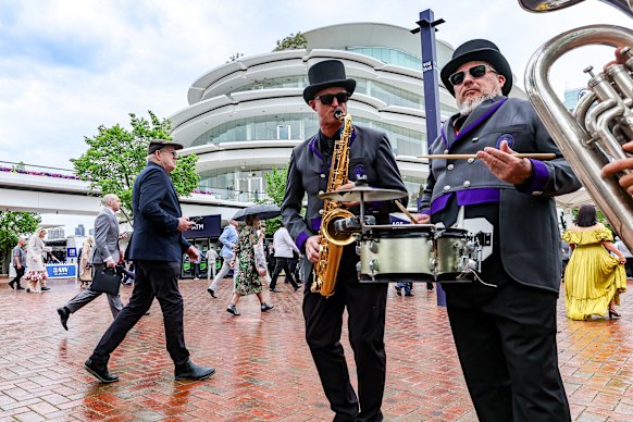 The band plays as punters arrive at the races.