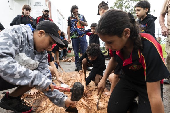 Students from Dalaigur Pre-School and surrounding schools help strip back layers of bark. 