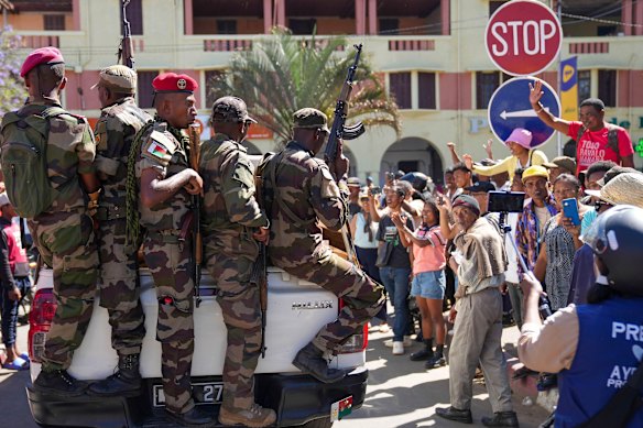 People greet soldiers in Antananarivo, Madagascar on Sunday.