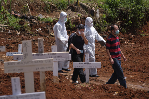 A family at the grave of their relative who died of coronavirus in one of the two official cemeteries for COVID-19 victims in Jakarta, Indonesia.