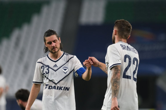 Jake Brimmer, right, and Marco Rojas, left, console each other after Melbourne Victory’s loss in Qatar. 