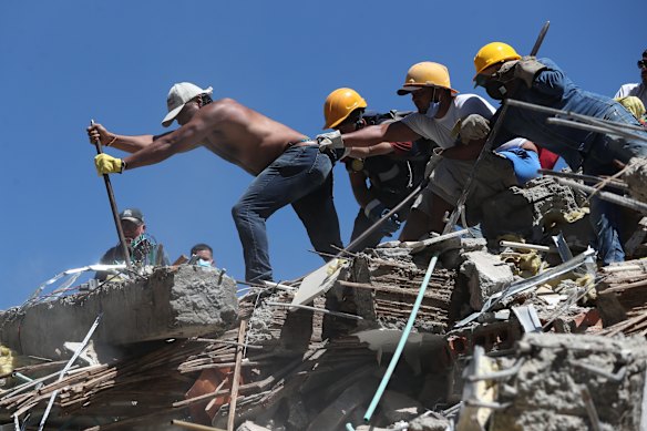 Residents and rescue workers in Cali search through the rubble.