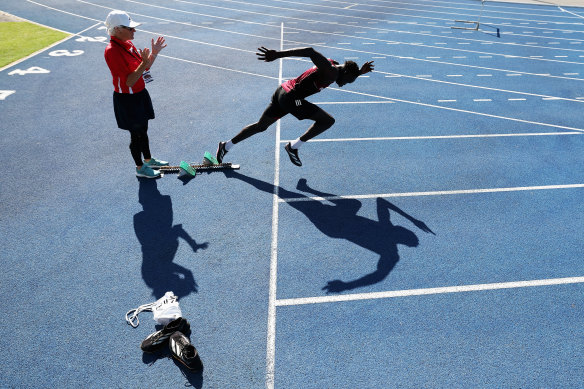 Gout Gout warms up for his Boys’ U18 100m final with his coach Di Sheppard during the 2024  Australian All Schools Athletics Championship at Queensland Sport and Athletics Centre on December 06, 2024 in Brisbane.
