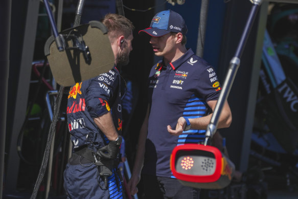 Max Verstappen talks with a Red Bull colleague after his exit.