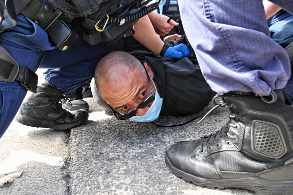 A man is pinned to the ground by police.