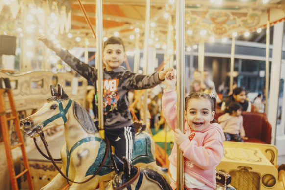 Anthony el Maydaa, 7, and his sister Tina, 3, riding the carousel on holiday from Canberra.