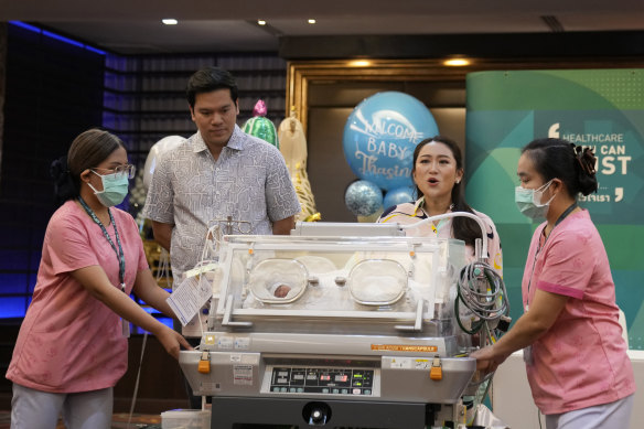Paetongtarn Shinawatra (second from right) presents her newborn son to media with her husband Pidok Sooksawas.