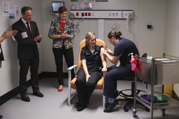 Minister for Health and Aged Care Greg Hunt and ACT Minister for Health Rachel Stephen-Smith observe as COVID testing nurse Maddy Williams receives the first COVID-19 vaccination in the ACT.